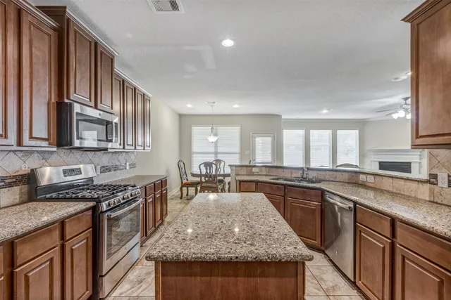 a kitchen with stainless steel appliances granite countertop a sink stove and cabinets