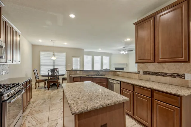 a kitchen with granite countertop sink cabinets and stainless steel appliances
