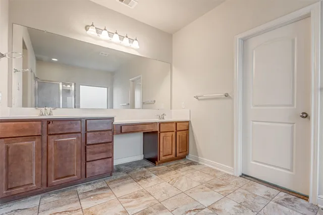 a spacious bathroom with a granite countertop sink a mirror and a vanity