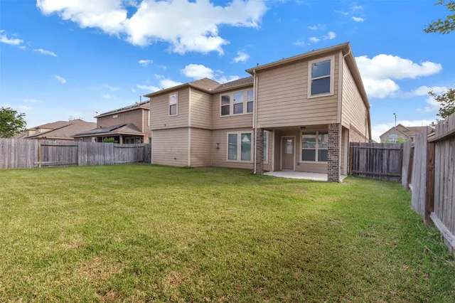 a view of a house with a backyard and a tree