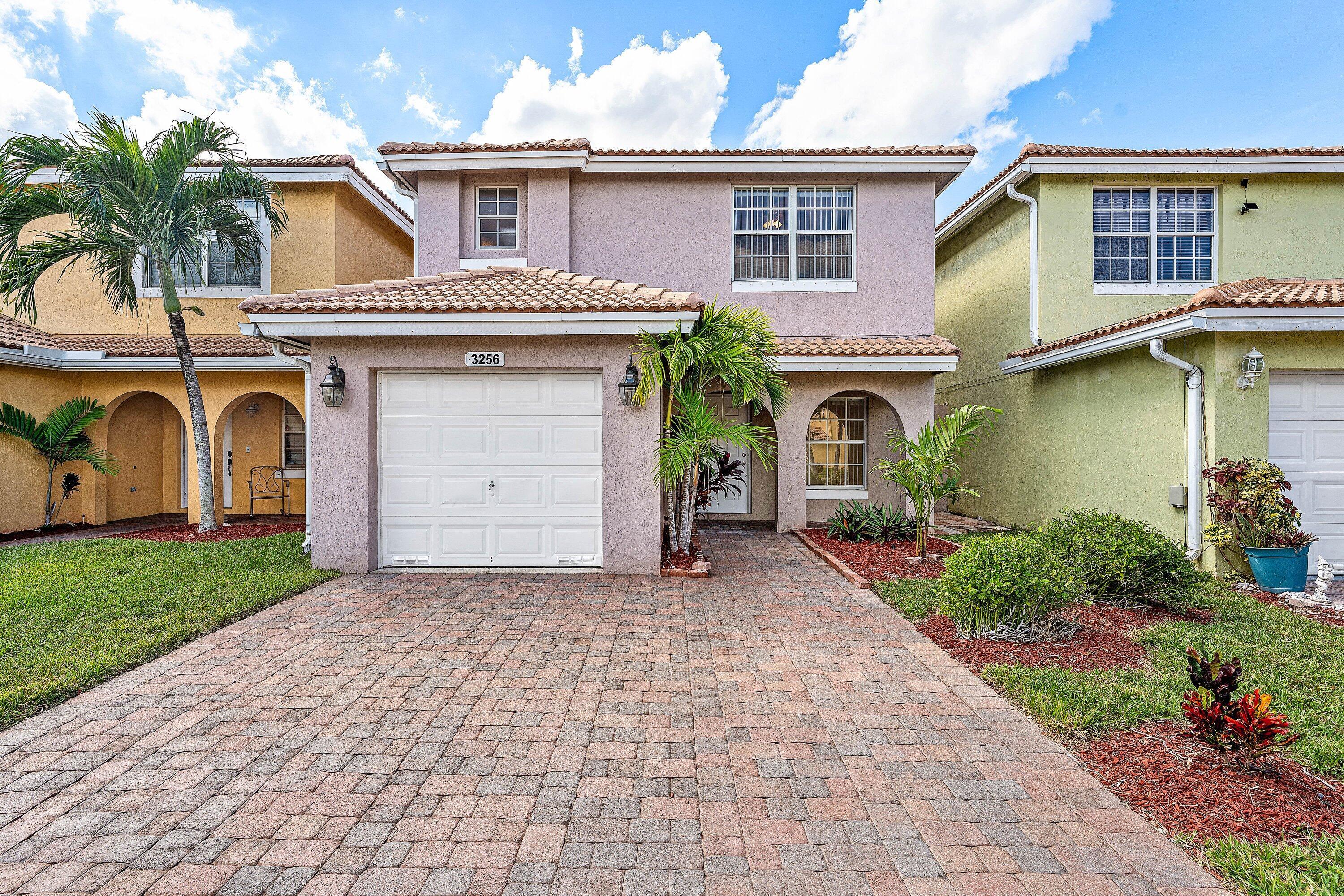 a front view of a house with a garden and plants