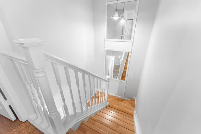 a view of a hallway with wooden floor and staircase
