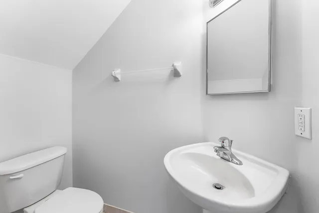 a bathroom with a sink mirror and toilet