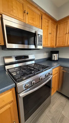 a kitchen with granite countertop a stove and a microwave