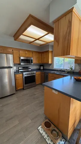 a kitchen with stainless steel appliances a stove a sink and a refrigerator