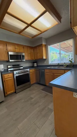 a kitchen with stainless steel appliances granite countertop a stove a sink and a microwave