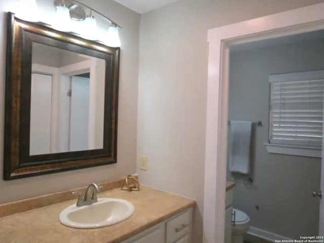 a bathroom with a toilet sink and mirror