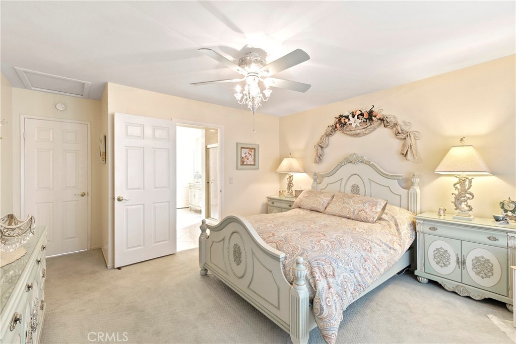 762 Torrey Pines Road Banning, CA 92220 - Photo 23 of 43 a spacious bedroom with a bed and a chandelier