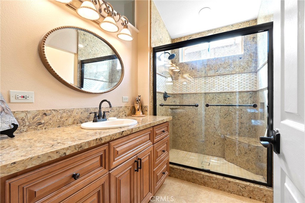 762 Torrey Pines Road Banning, CA 92220 - Photo 32 of 43 a bathroom with a granite countertop sink mirror and shower