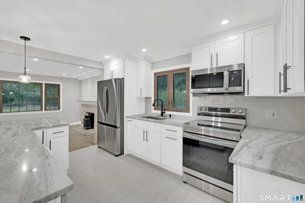 a kitchen with stainless steel appliances granite countertop a stove a sink and a refrigerator