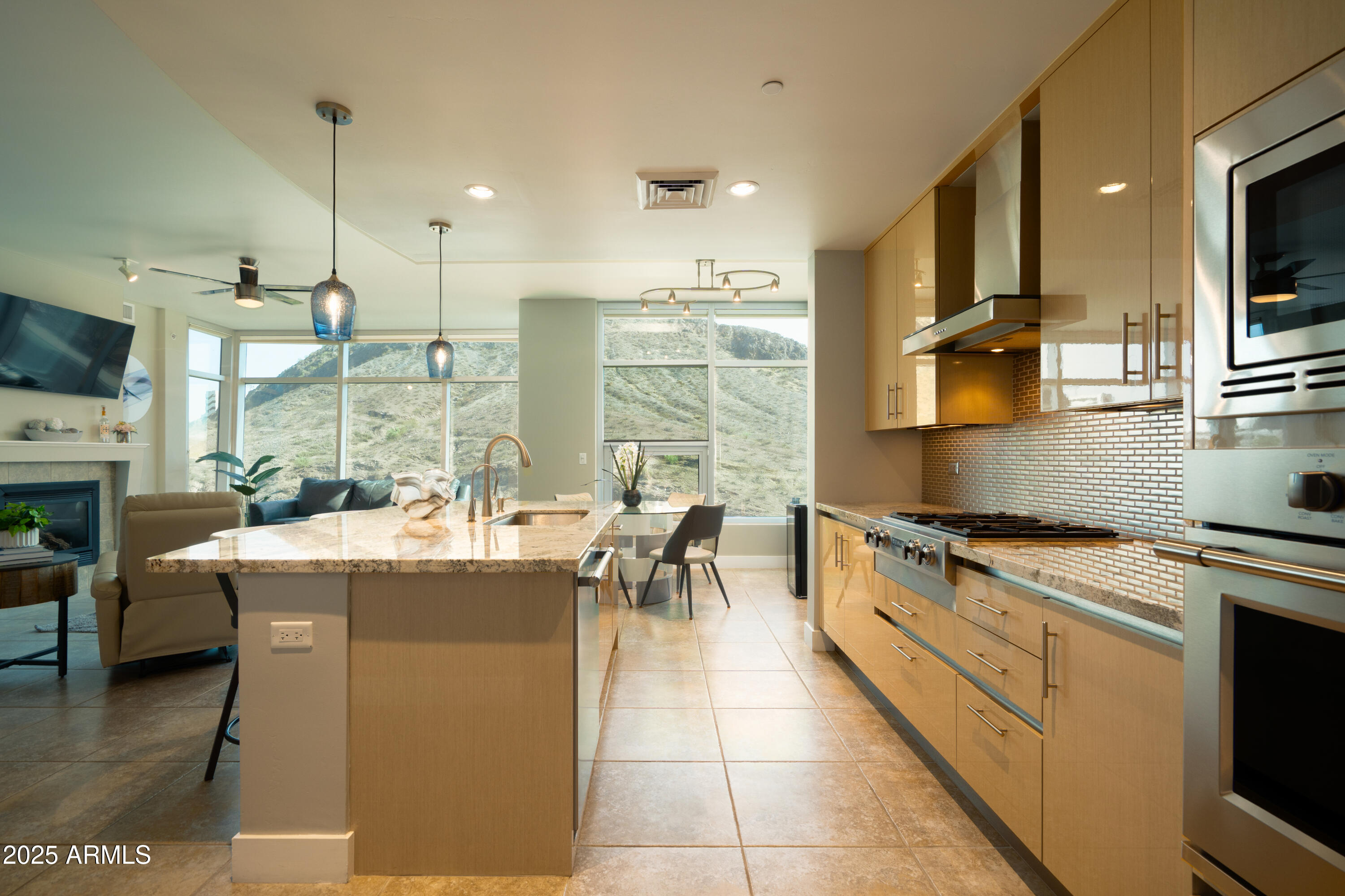 a kitchen with stainless steel appliances granite countertop a stove and a view of living room