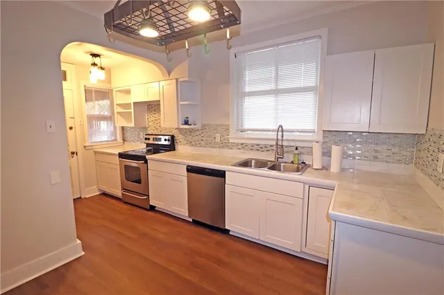 a kitchen with stainless steel appliances a white stove top oven sink and window