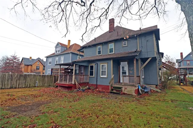 a view of a house with a yard and wooden fence