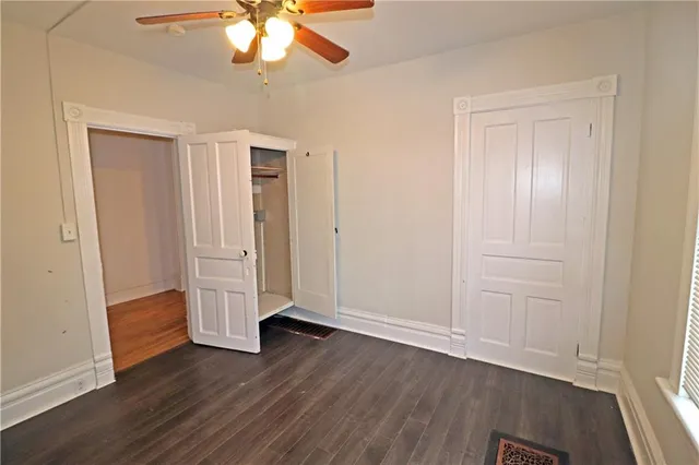 an empty room with wooden floor and closet area