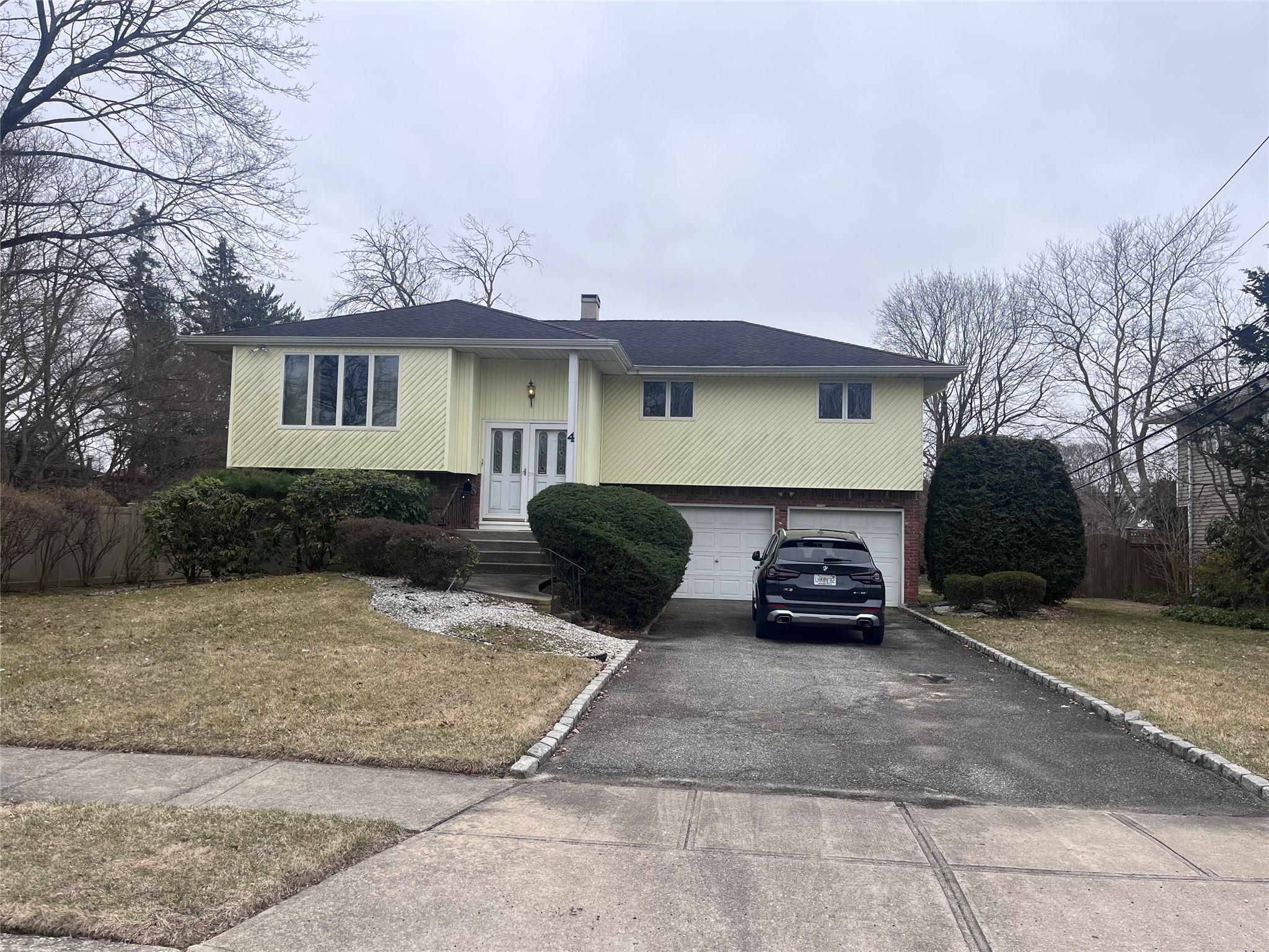 4 Farmstead Road Commack, NY 11725 - Photo 1 of 1 Split foyer home with asphalt driveway, a chimney, a garage, and french doors