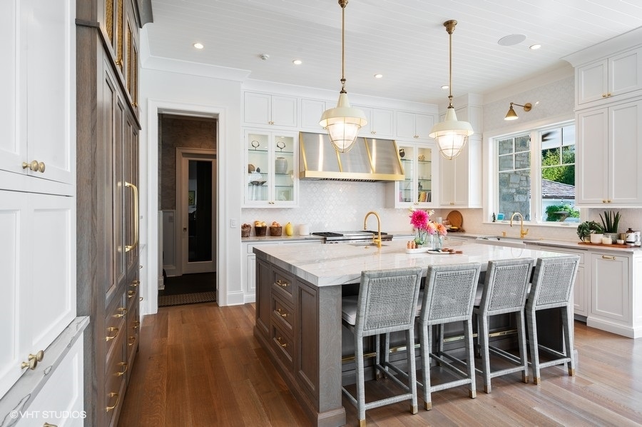 844 Prospect Avenue Winnetka, IL 60093 - Photo 7 of 27 a kitchen with stainless steel appliances granite countertop a kitchen island a stove a refrigerator and a dining table with wooden floor