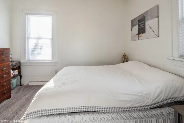 a bed sitting in a bedroom next to a window