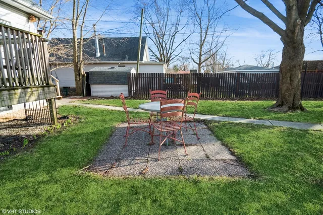 a view of a chair and table in backyard of the house