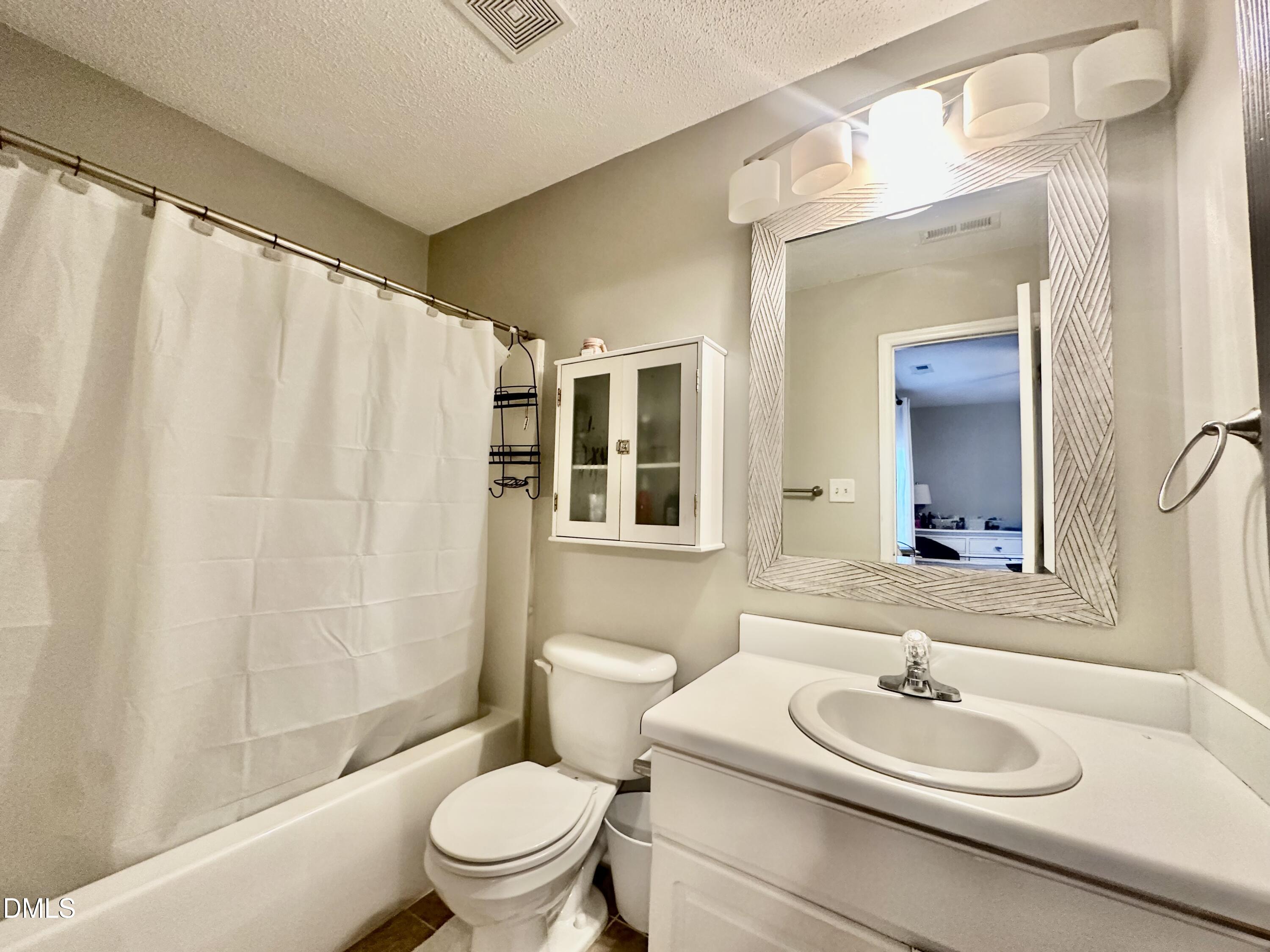 2106 Walnut Bluffs Lane Raleigh, NC 27610 - Photo 13 of 15 a bathroom with a sink a toilet and a mirror