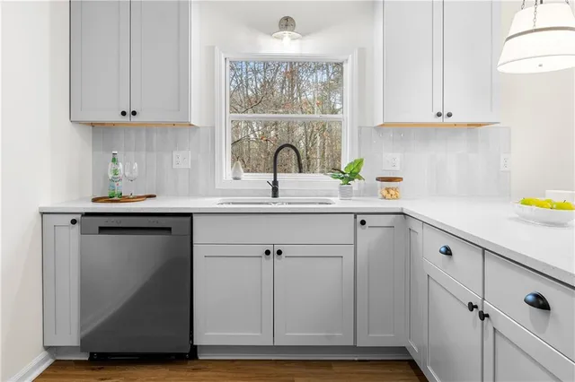 a kitchen with stainless steel appliances granite countertop a sink cabinets and a window