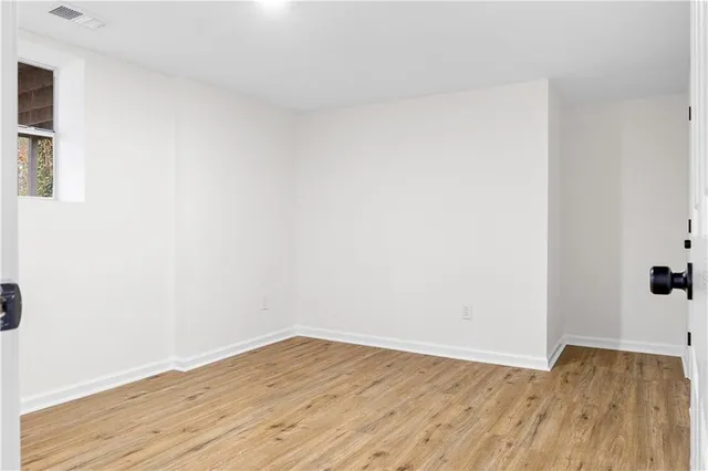 a view of a small space with wooden floor and window