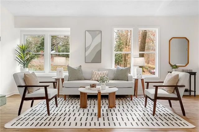 a living room with furniture a large window and a table