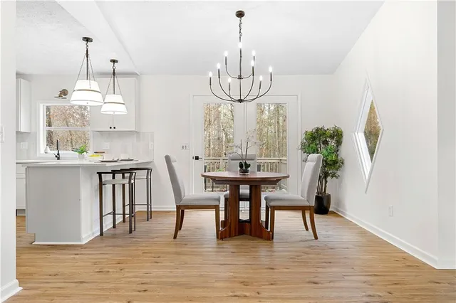a dining room with furniture a chandelier and wooden floor