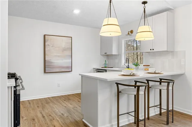 a kitchen with stainless steel appliances granite countertop a sink a stove and a wooden floors