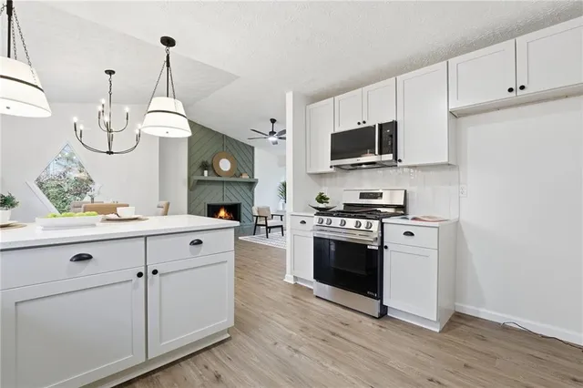 a kitchen with white cabinets and stainless steel appliances