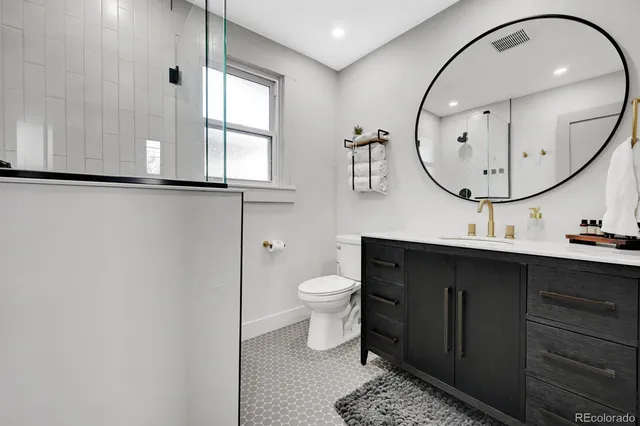 a bathroom with a toilet a sink and mirror