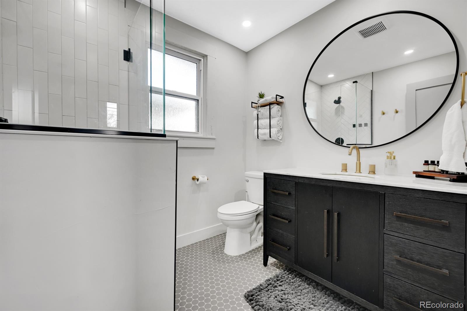 1402 Meade Street Denver, CO 80204 - Photo 11 of 23 a bathroom with a toilet a sink and mirror