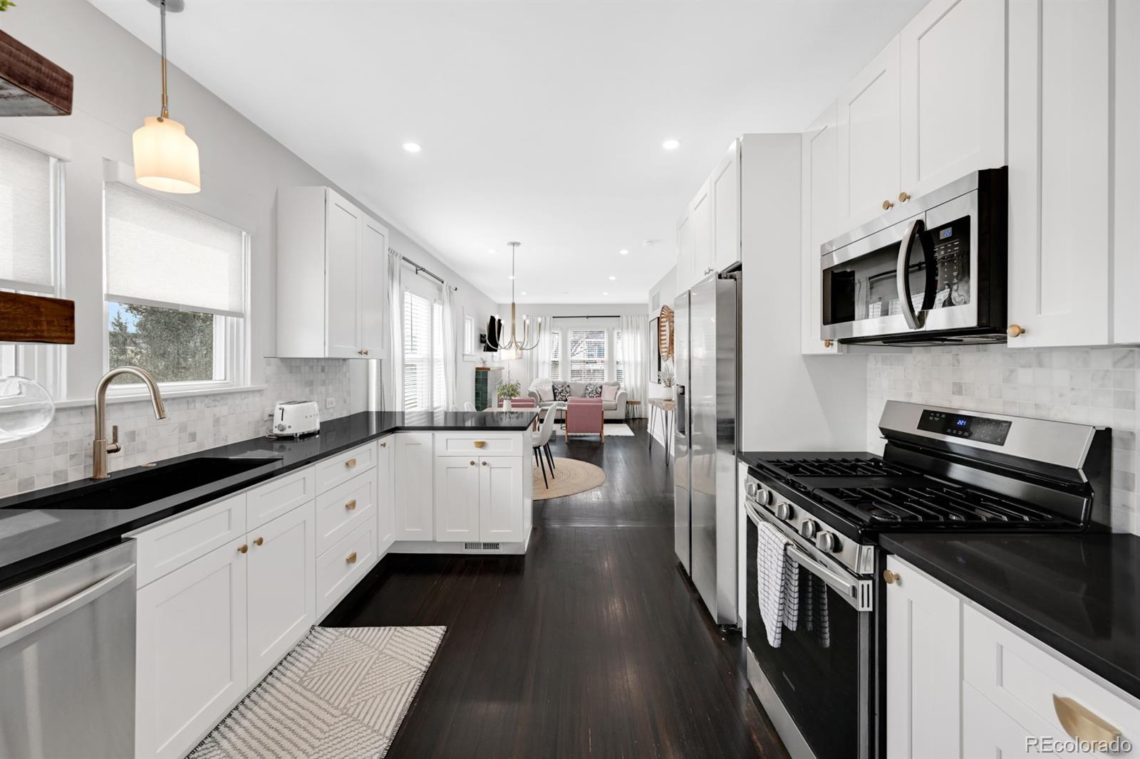 1402 Meade Street Denver, CO 80204 - Photo 3 of 23 a kitchen with stainless steel appliances a stove sink microwave and cabinets