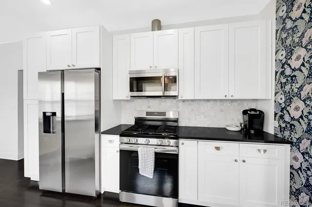 a kitchen with stainless steel appliances a refrigerator a stove a microwave and cabinets