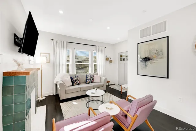 a living room with furniture a flat screen tv and a fireplace