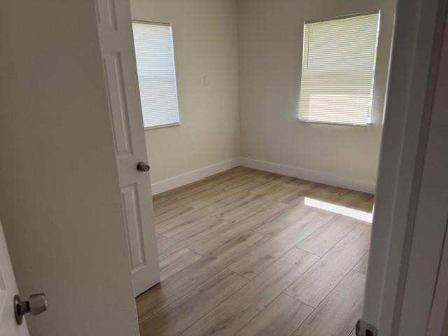 141 Southeast 7th Avenue Boynton Beach, FL 33435 - Photo 4 of 7 an empty room with wooden floor and windows