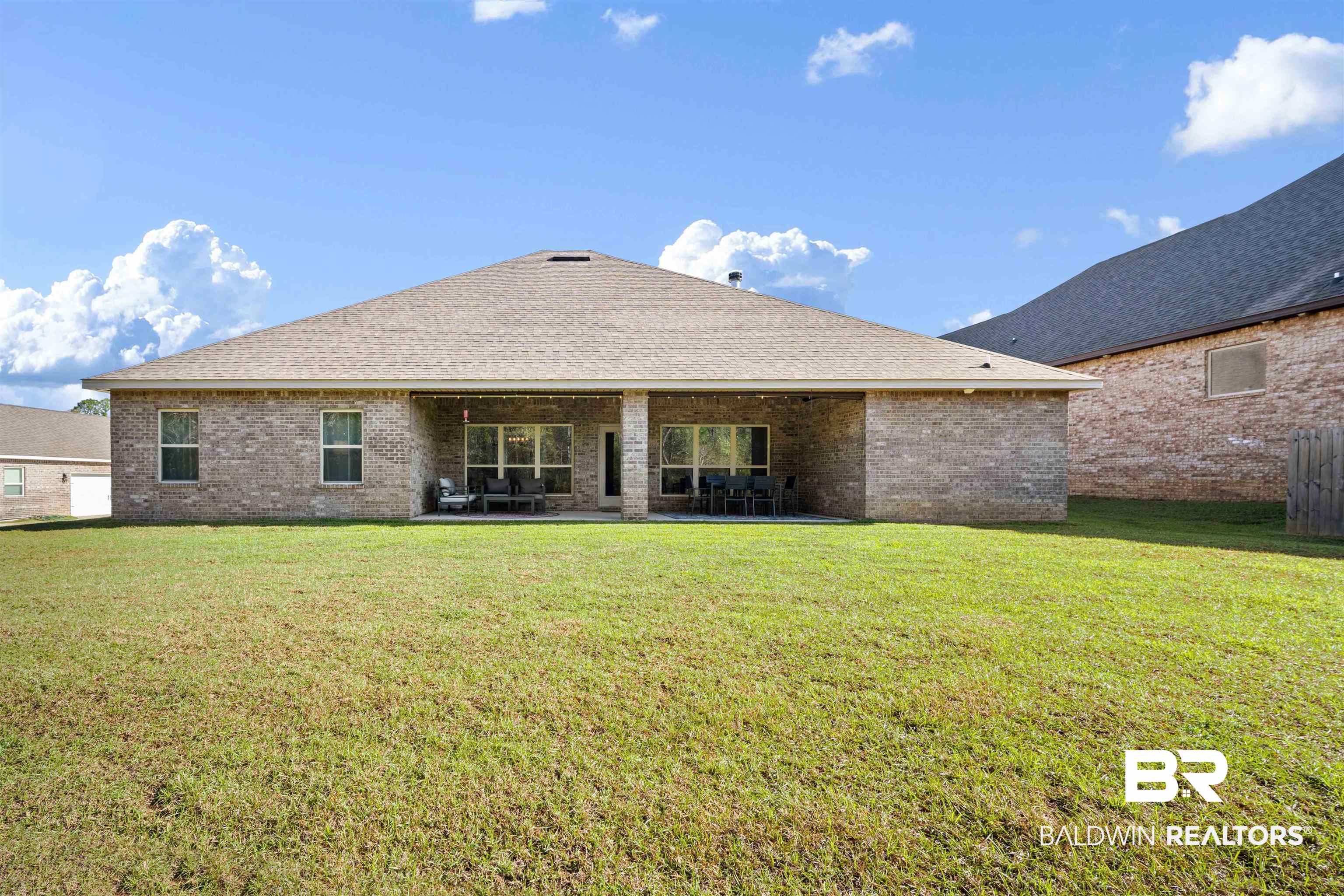 1700 Gwin Court Mobile, AL 36695 - Photo 34 of 36 Back of house with brick siding, a yard, a patio area, and a shingled roof