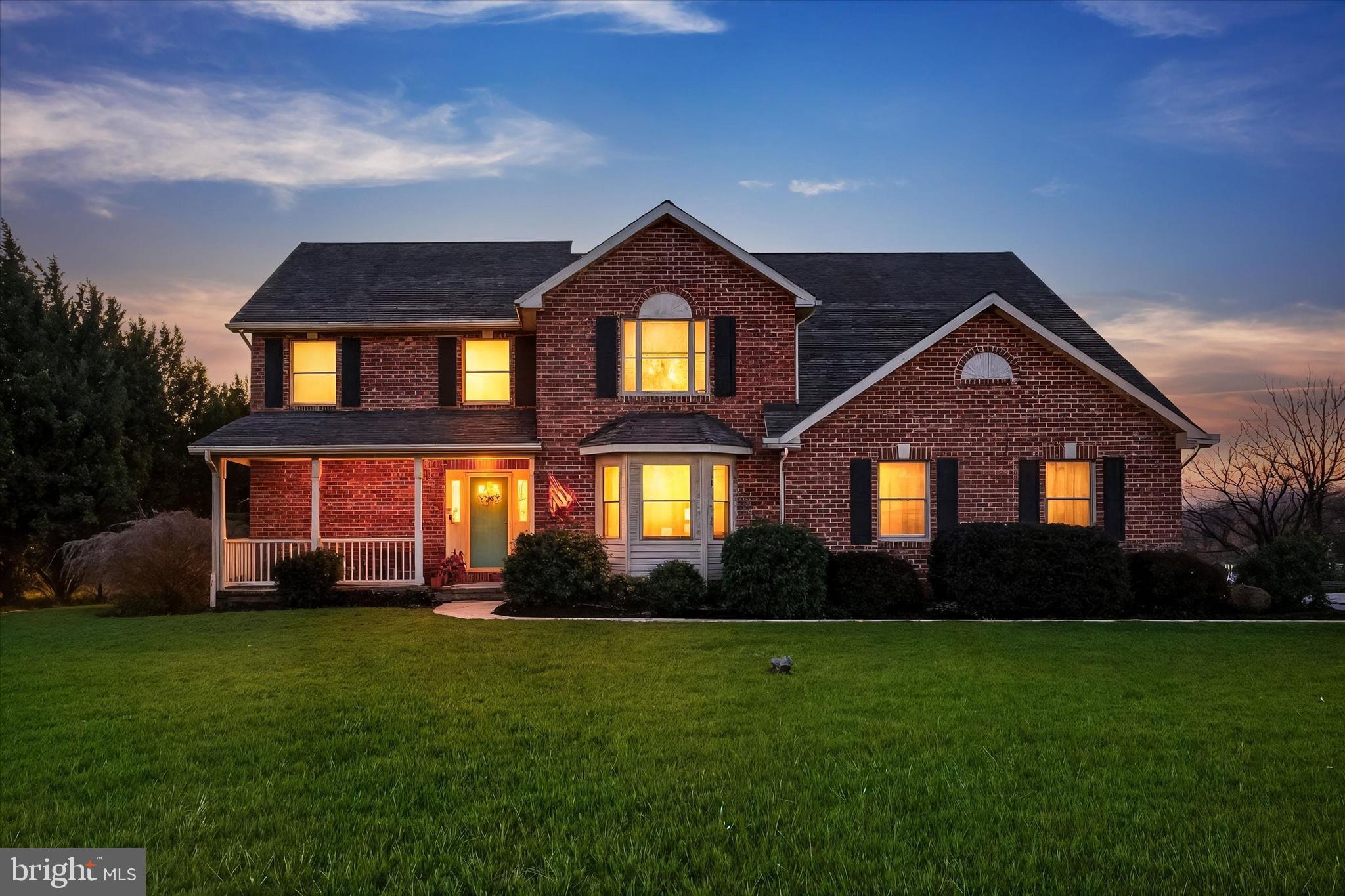 a front view of a house with a yard and green space
