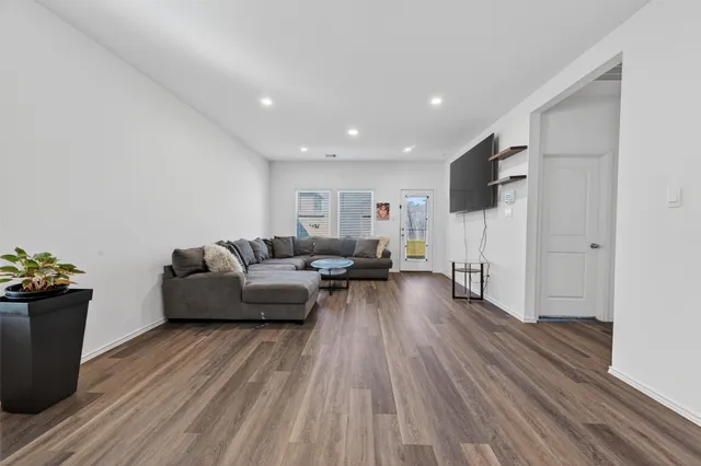 a living room with furniture and a wooden floor