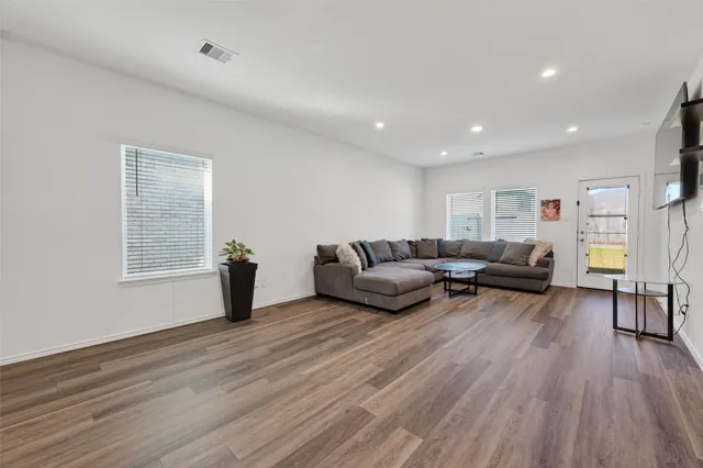 a living room with furniture and a wooden floor