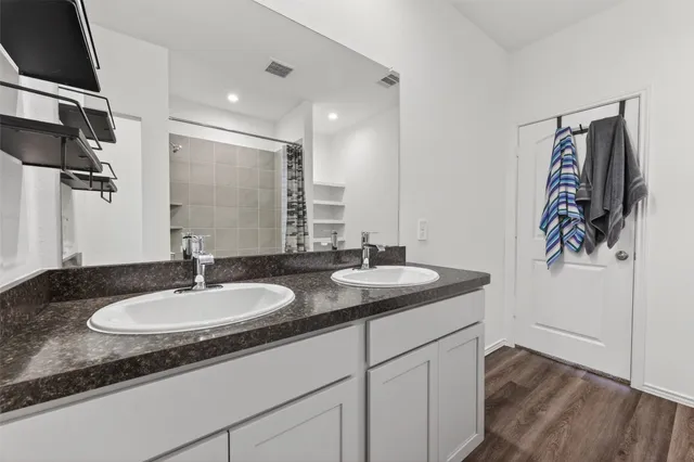 a bathroom with a granite countertop sink and a mirror