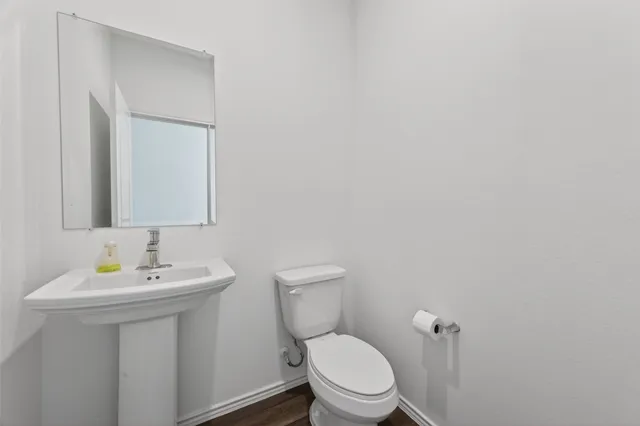 a bathroom with a sink mirror and toilet