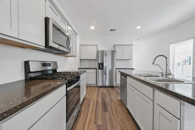 a kitchen with stainless steel appliances granite countertop a stove sink and cabinets