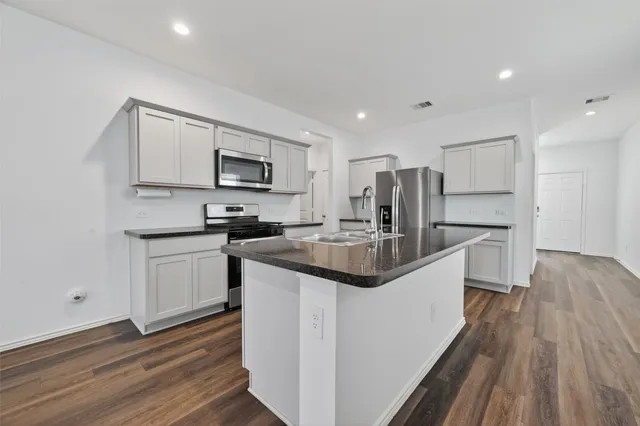 a kitchen with stainless steel appliances granite countertop a sink stove and refrigerator