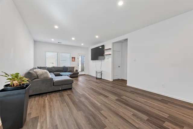 a living room with furniture and a wooden floor