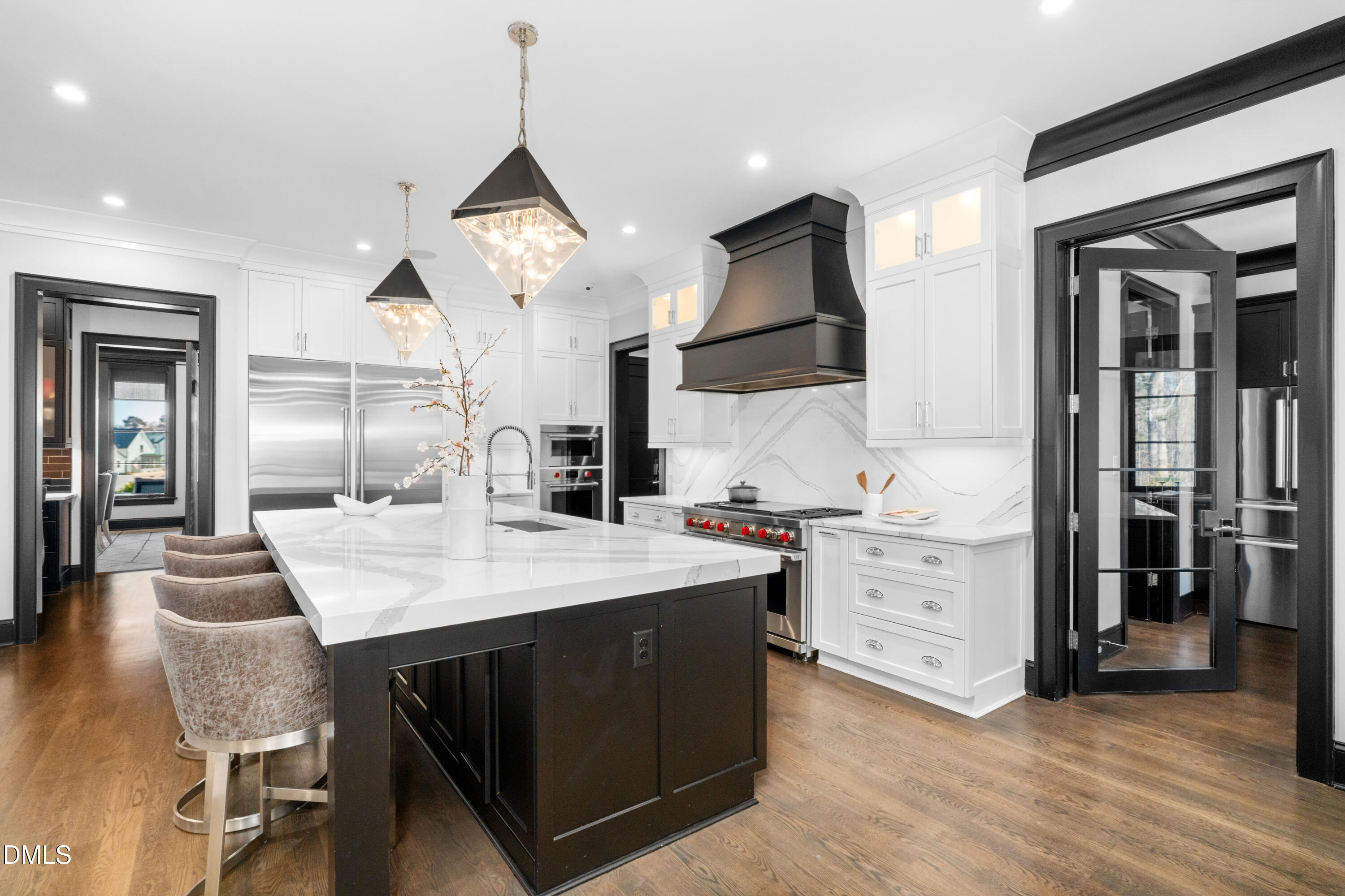 6508 Century Oak Court Raleigh, NC 27613 - Photo 5 of 91 a large kitchen with kitchen island a stove a sink a center island and a wooden floor