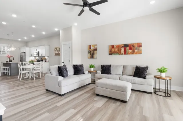 a living room with furniture and a wooden floor