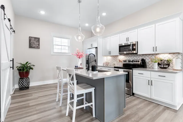 a kitchen with kitchen island granite countertop a sink cabinets and wooden floor