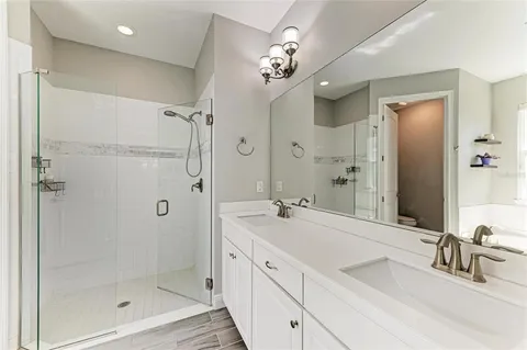 a bathroom with a granite countertop sink a mirror a shower and a bathtub