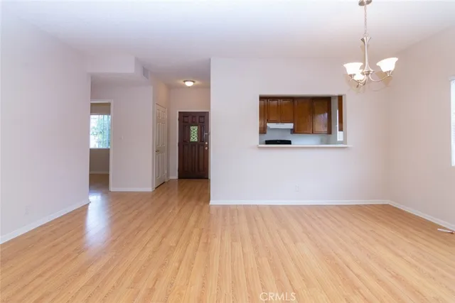 a view of a room with wooden floor and chandelier