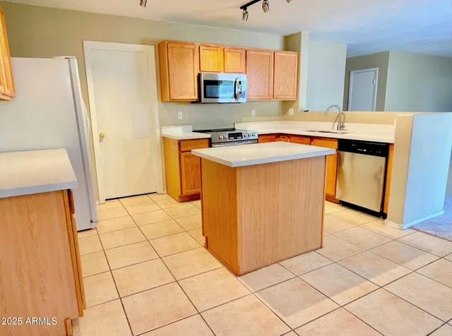 a view of kitchen with stainless steel appliances a sink and a refrigerator